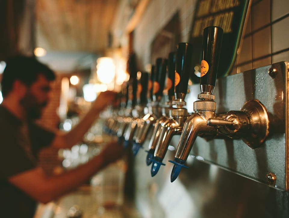 Iconic Florida 4 A bar tender is blurred in the background seemingly serving up an iconic Florida brew at Intuition Ale Works. In the foreground are beer taps.