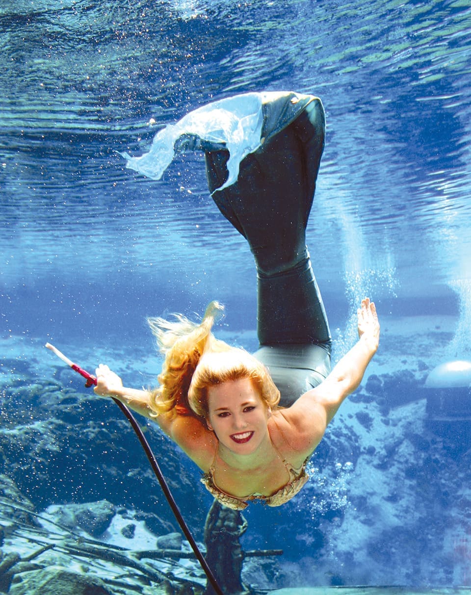 Iconic Florida 6 An iconic Weeki Wachi mermaid smiles as she swims under water. Her tails flows in the blue water