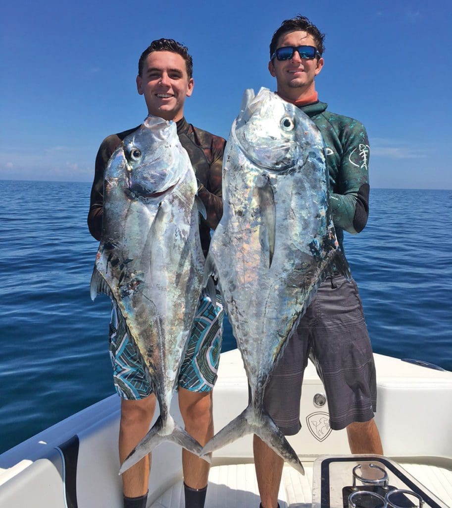 2 men holding up fish
