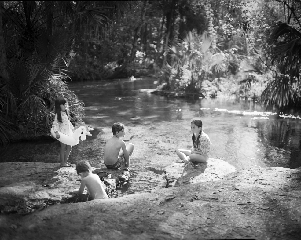 kids sit on a rock by a spring in Central Florida