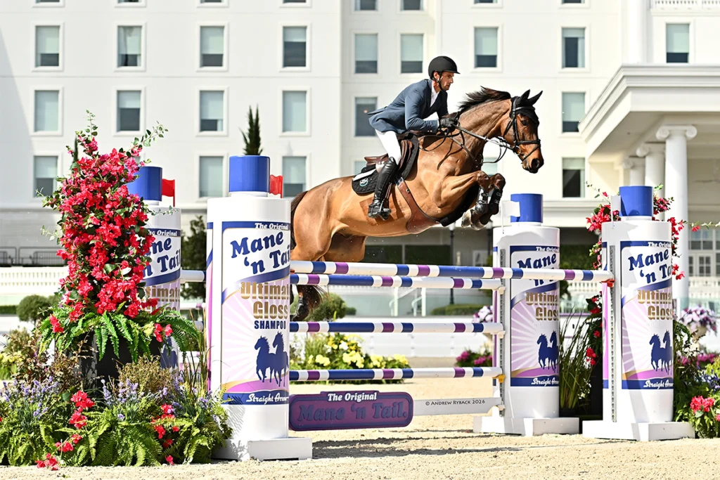 Horse jumping over barrier at World Equestrian Center.