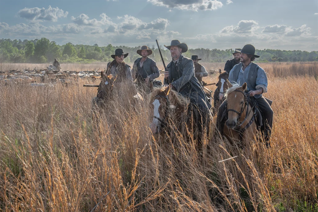 Cowboys ride on horseback while filming "A Land Remembered."