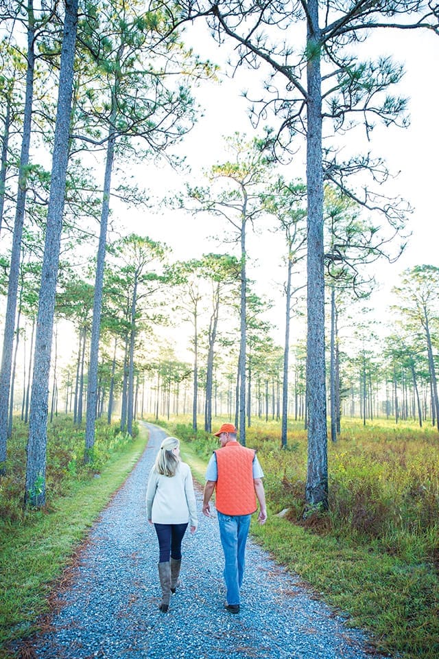 Slade Sykes and a Baker family member walk through the longleaf pine forest on a recent fall morning
