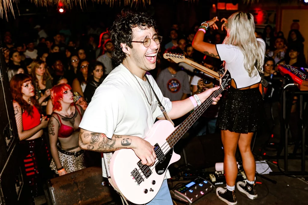 Andy Gil shreds onstage while Raquel Lily engages with fans.