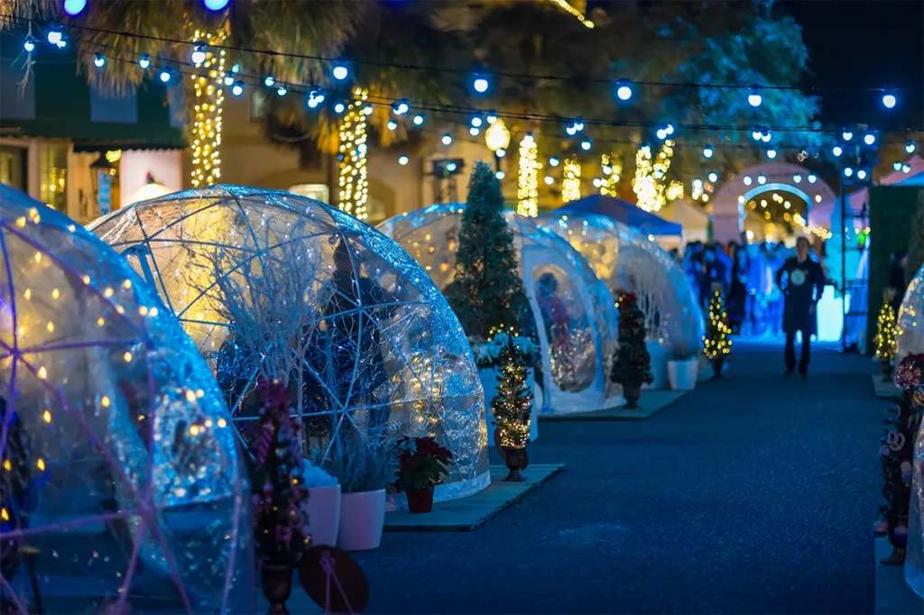 Heated life-size snow globes for guests to enjoy snacks and refreshments inside.